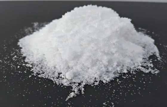 该氨基磺酸为白色结晶粉末，堆成凸起料堆，带有细碎晶块，四周散落细小粉体，无明显特殊气味。
